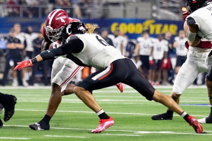 Alabama running back Brian Robinson Jr. (4) is tackled by Cincinnati safety Bryan Cook (6) in the NCAA Playoff Semifinal. Albert Cesare / The Enquirer / USA TODAY NETWORK